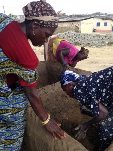 Building Livelihoods from the Ground Up; Beneficiaries Pound Bricks Before Smoking Fish